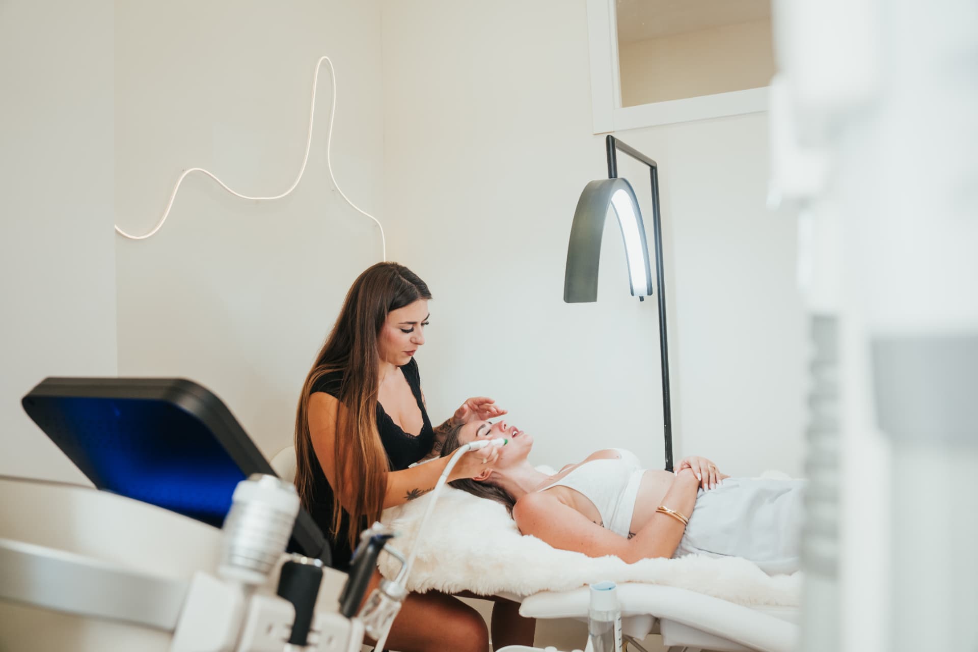 Vista amplia de Kimberley realizando un facial con equipamiento profesional